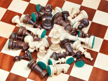 white king in middle of spillage of chess pieces on chessboard