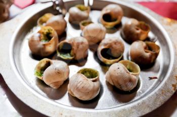 Plate of escargot shells, with special tongs and fork