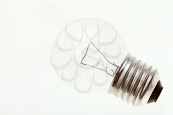 small transparent incandescent light bulb on white surface