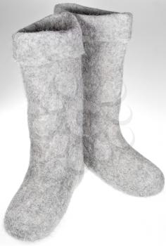 knee-high felt boots on grey background