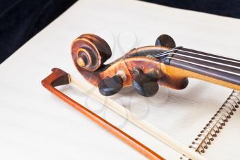 violin bow and scroll on music book close up
