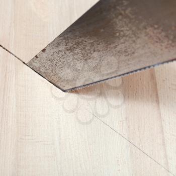 wooden board is cut with hacksaw close up