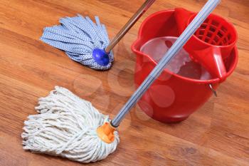 washing of wood floors by two mops and red bucket