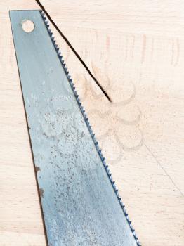 hacksaw at beech wood board