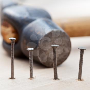 hammer and nails into wooden plank close up