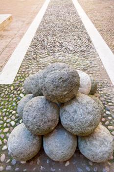 old stone cannon ball on courtyard of The Castle Estense in Ferrara, Italy