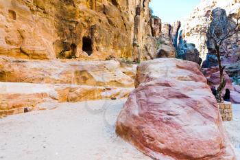 eroded sandstone rocks and colored mountains in gorge Siq in Petra, Jordan 