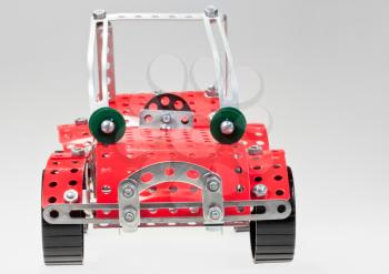 red retro car from metal construction set on grey background