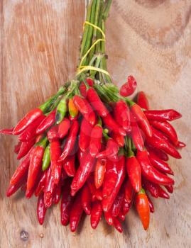 bunch of fresh small cayenne red pepper on wood table