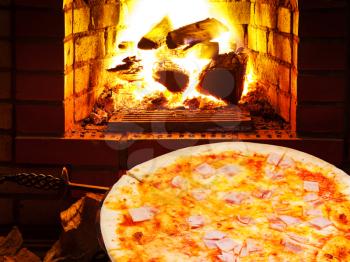 italian pizza with prosciutto cotto and open fire in wood burning oven