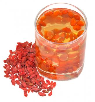 preparing of goji berry tincture - glass with goji berries infusion and heap of dried fruits isolated on white background