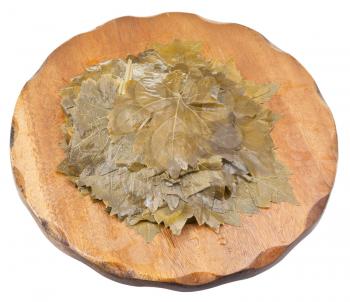 salted grape leaves on wooden cutting board isolated on white background