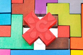 cross shaped piece on wooden multicoloured puzzle isolated on white background