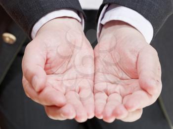front view of businessman holding empty handful from two palms- hand gesture