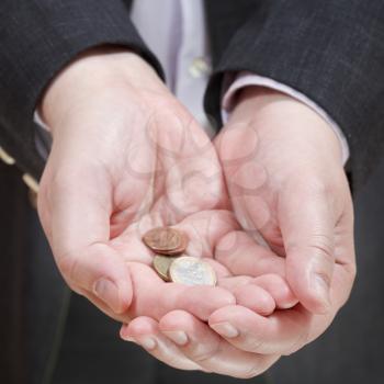little of coins in businessman's handful close up