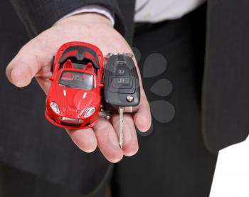 red car and key in salesman's hand close up