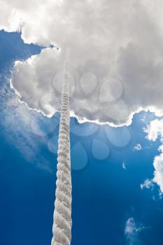 tightrope rises to clouds in dark blue sky