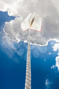 book tied on cord soars into dark blue sky