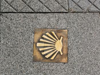 marker in the pavement indicates the route of the Way of St. James