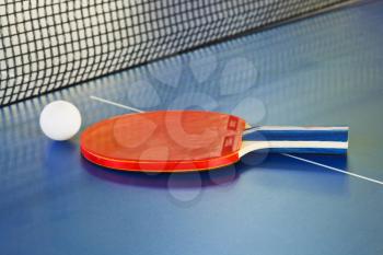 red paddle, tennis ball on ping pong sport table close up