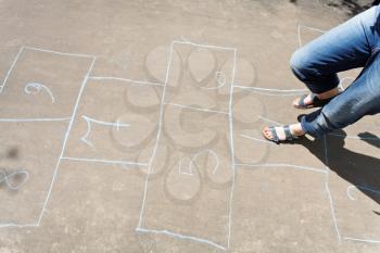 playing in hopscotch outdoors in sunny day
