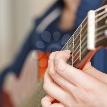 woman playing classical acoustic guitar close up