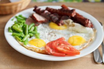 breakfast with fried eggs, sausages, tomato, beans