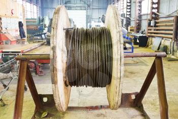 industrial wooden reel with steel rope in mechanical workshop