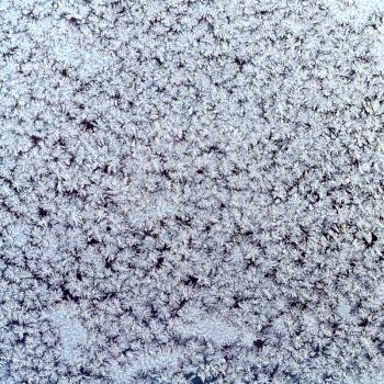 winter background - snowflakes and frost on frozen window dlass