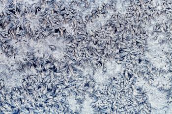 winter background - snowflakes and frost on frozen glass