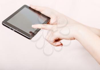 girl holding and clicking tablet-pc screen on pink background