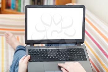 man writes on laptop with cut out screen in living room