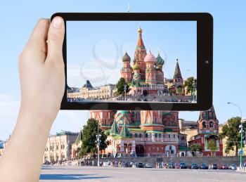 travel concept - tourist taking photo of Red Square with Vasilevsky descent in Moscow, Russia on mobile gadget