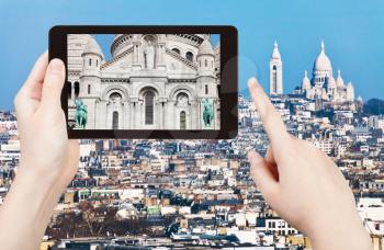 travel concept - tourist taking photo panorama of montmartre hill and basilique sacre coeur in Paris on mobile gadget, France
