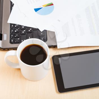 business workflow - above view mug of coffee and tablet pc on office table