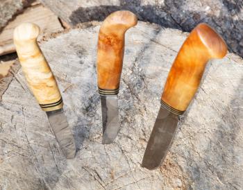 three bowie knives thrust in tree stump