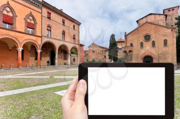 travel concept - tourist photograph Santo Stefano square with ancient temples Sette Chiese (Seven Churches) in Bologna, Italy on tablet pc with cut out screen with blank place for advertising logo