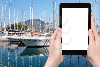 travel concept - tourist photograph yachts and boats in old port in Palermo, Italy on tablet pc with cut out screen with blank place for advertising logo