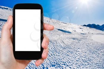 travel concept - tourist photograph blue cold snow on Alps mountain in Portes du Soleil region, Morzine - Avoriaz, France on tablet pc with cut out screen with blank place for advertising logo