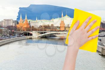 travel concept - hand deletes morning view of Moscow by yellow cloth from image and evening cityscape is appearing