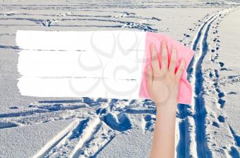 season concept - hand deletes winter snow field by pink rag from image and white empty copy space are appearing