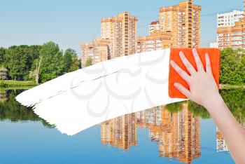 ecology concept - hand deletes new houses by orange rag from image and white empty copy space are appearing