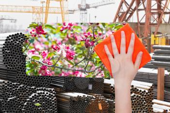 ecology concept - hand deletes industrial landscape by orange cloth from image and spring pink blossoms are appearing