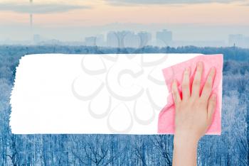 weather concept - hand deletes frozen forest by pink rag from image and white empty copy space are appearing