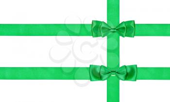 two double little green bow knots on three satin ribbons isolated on white background