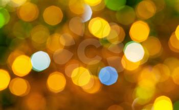 abstract blurred background - brown and green shimmering Christmas lights bokeh of electric garlands on Xmas tree