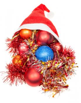christmas gifts - xmas balls and decorations in red santa hat on white background