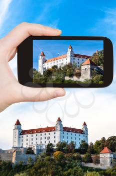 travel concept - tourist snapshot of Bratislava Hrad castle on smartphone