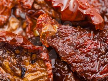 food background - dried red tomatoes in olive oil close up