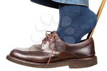 man puts on brown shoes using shoe horn isolated on white background